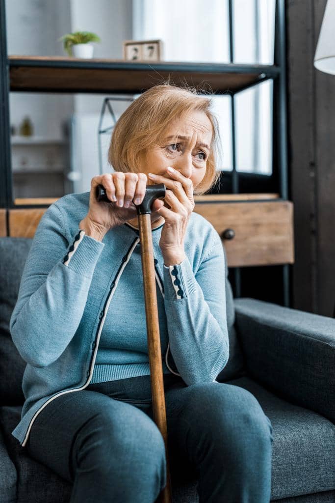 7 Emotional Pitfalls You Need to Avoid During Gray Divorce 4 upset senior woman holding walking stick covering mouth hand crying