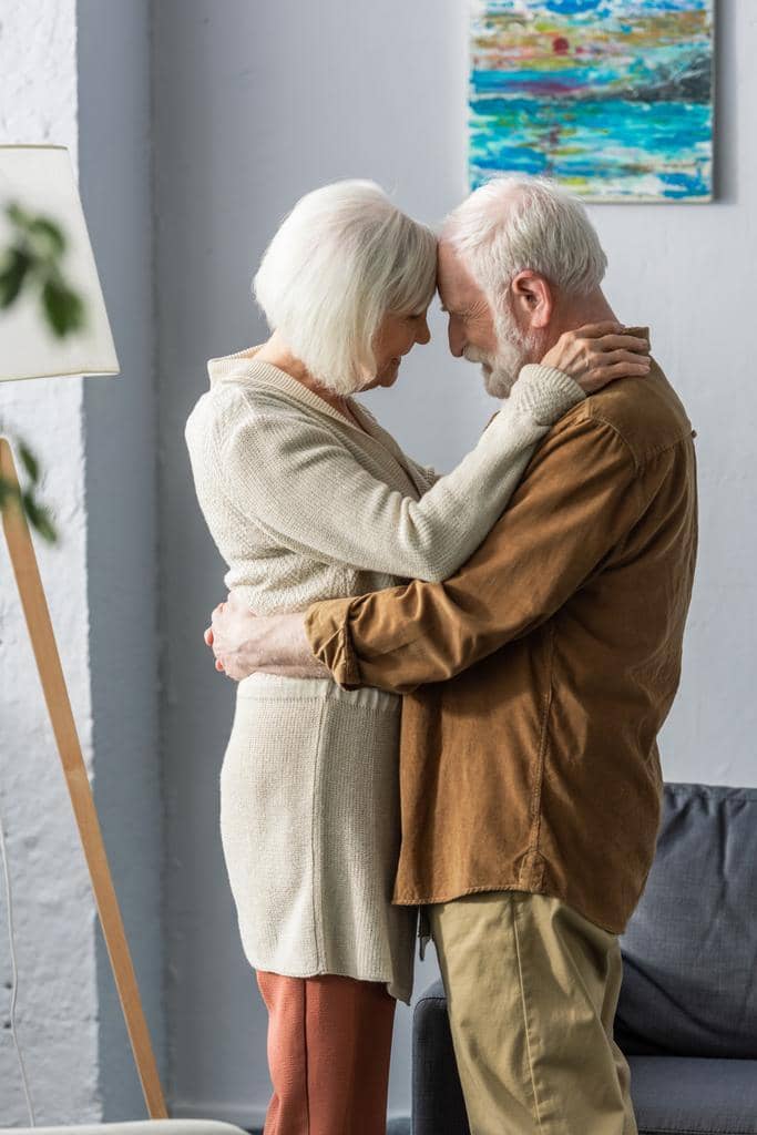 Why Marriage Gets Harder After 50: 9 Unique Challenges 7 side view happy senior couple embracing smiling while standing face
