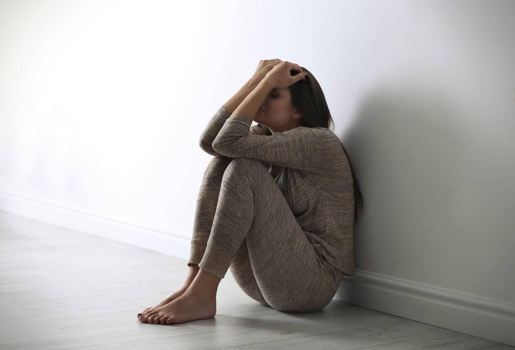 Reframing Guilt From Divorce: Turn Divorce Shame into Growth 2 depressed young woman sitting floor light wall