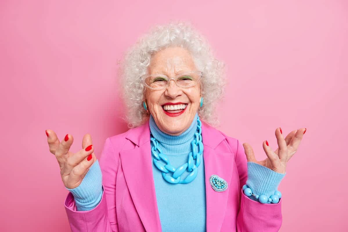 Happy senior woman against pink abckgrouind