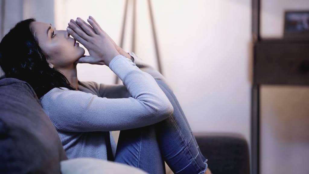 Walkaway Wife: 14 Important Questions to Contemplate Before Becoming One 10 stock photo depressed woman casual clothes sitting sofa praying hands mouth looking