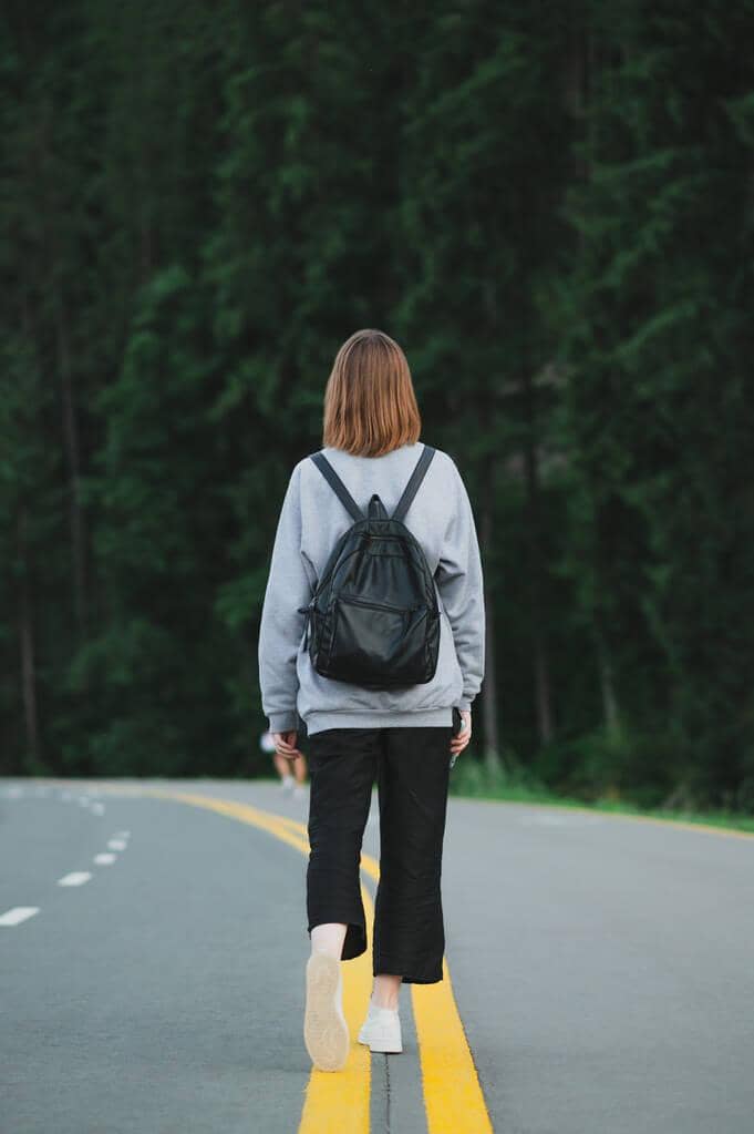 Walkaway Wife: 14 Important Questions to Contemplate Before Becoming One 2 girl casual clothes backpack walking asphalted forest road yellow