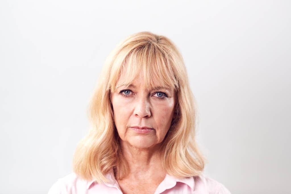5 Stealthy Resentment Stages in Relationships You Need to Avoid 6 unhappy frustrated mature woman white background camera