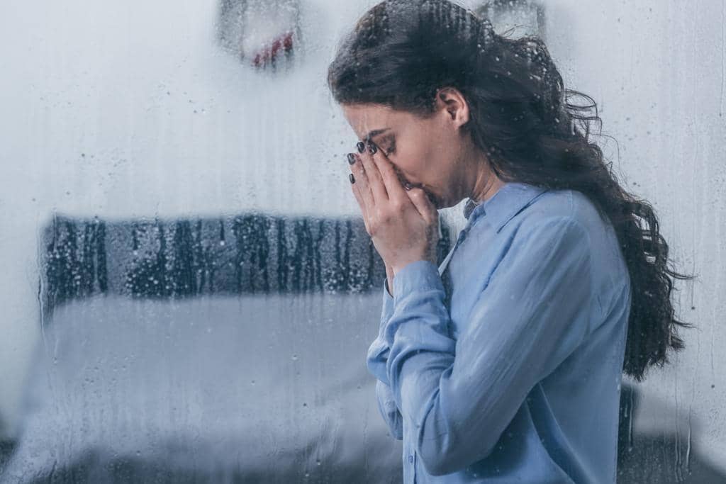 Empathic Rupture: When the Essential Bond of Empathy Breaks 7 depressed woman covering face hands crying home window raindrops