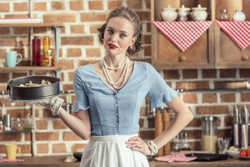 7 Surprising Ways Good Wife Syndrome Leads to Divorce 6 beautiful adult housewife holding baking trey looking camera kitchen