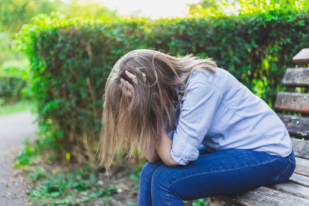 9 Ways Intermittent Reinforcement Keeps You Stuck in Toxic Relationships 2 sad depressed young woman holding her head both hands while