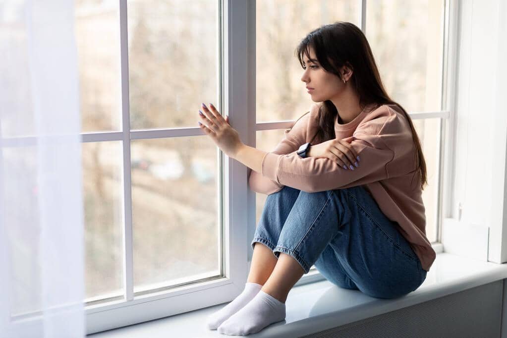 50 Painful Signs of an Emotionally Unavailable Husband 11 sad woman looking out of window at home