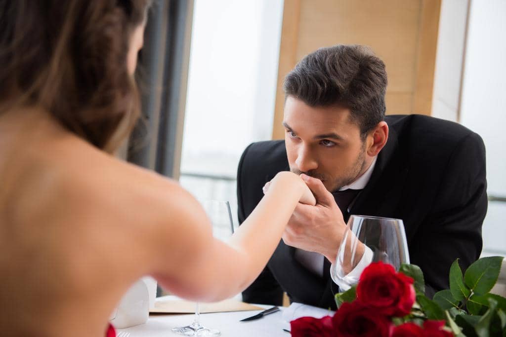 What's Behind the Alarming Decline in Dating Among Women? 4 partial view man kissing girlfirend hand romantic date restaurant valentine