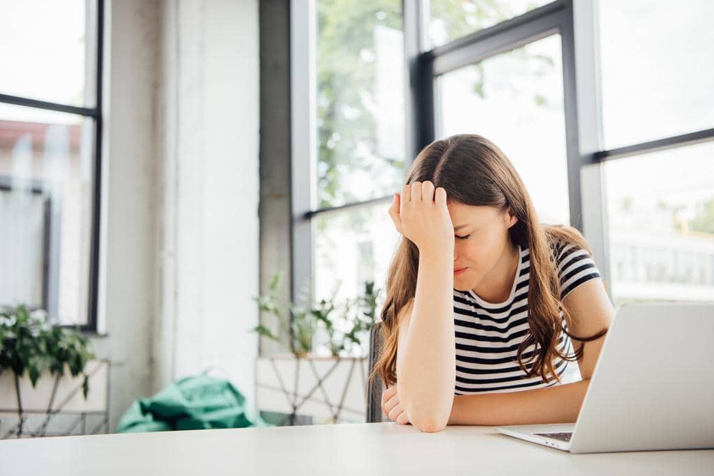 9 Ways Intermittent Reinforcement Keeps You Stuck in Toxic Relationships 5 sad girl striped shirt using laptop home
