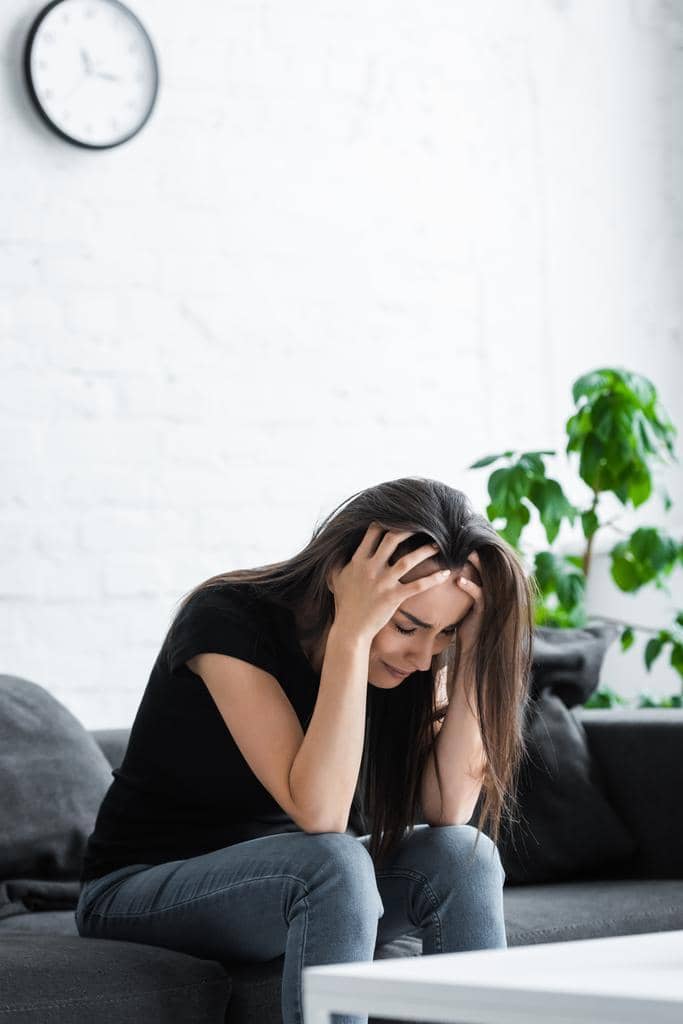 50 Painful Signs of an Emotionally Unavailable Husband 5 depressed girl crying while sitting couch home holding hands head