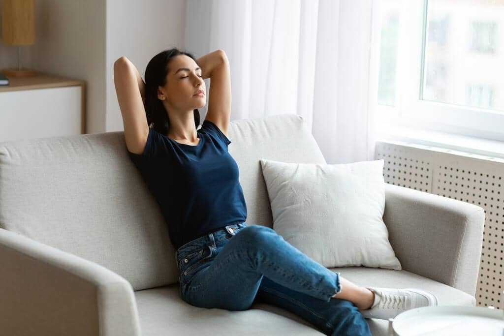 9 Ways Intermittent Reinforcement Keeps You Stuck in Toxic Relationships 11 peaceful woman relaxing with eyes closed sitting on sofa indoors
