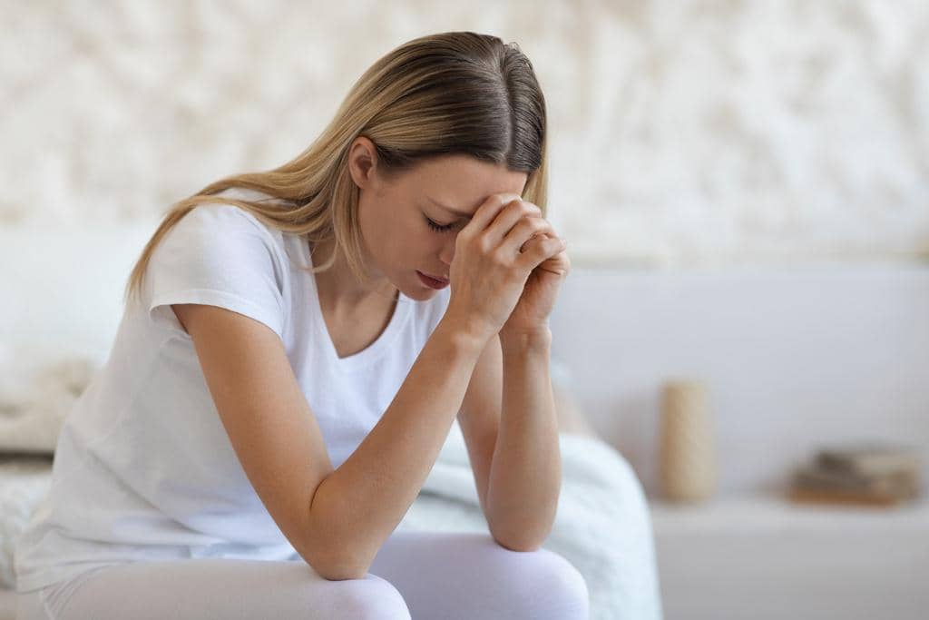 50 Painful Signs of an Emotionally Unavailable Husband 4 upset blonde lady sitting on bed at home crying