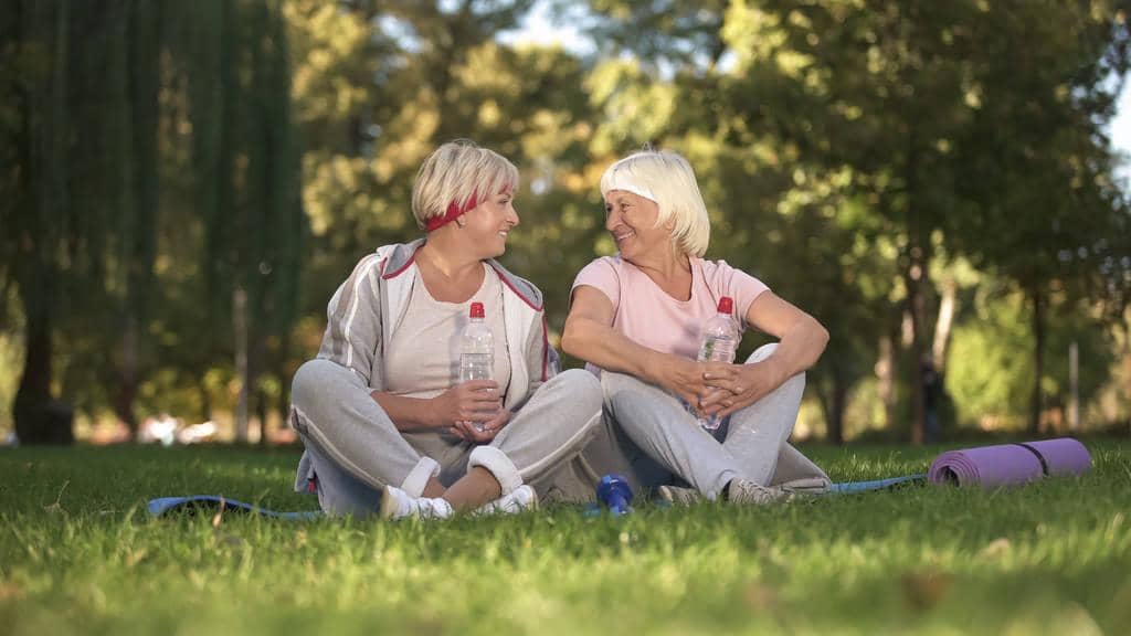 7 Devastating Financial Mistakes in Gray Divorce: How to Avoid Them 9 women chatting sitting grass yoga classes fresh air healthcare