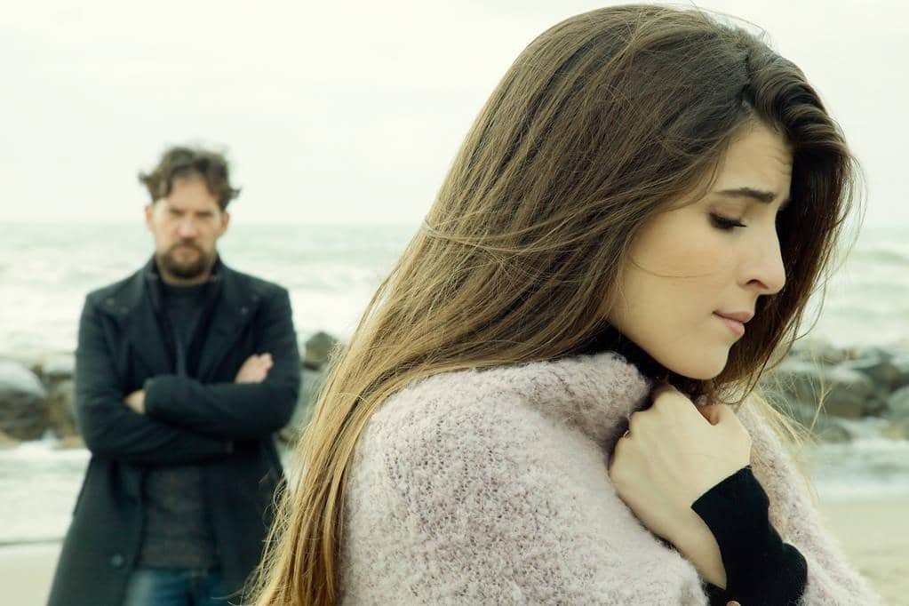 Closure After Divorce: 9 Painful Truths About Letting Go Gracefully 8 angry man looking sad girlfriend after fight in front of the ocean2