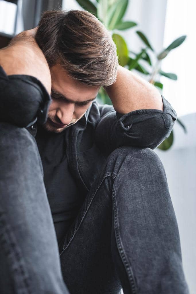7 Burning Examples of Trauma Adaptation in Relationships 5 handsome man headache touching head apartment