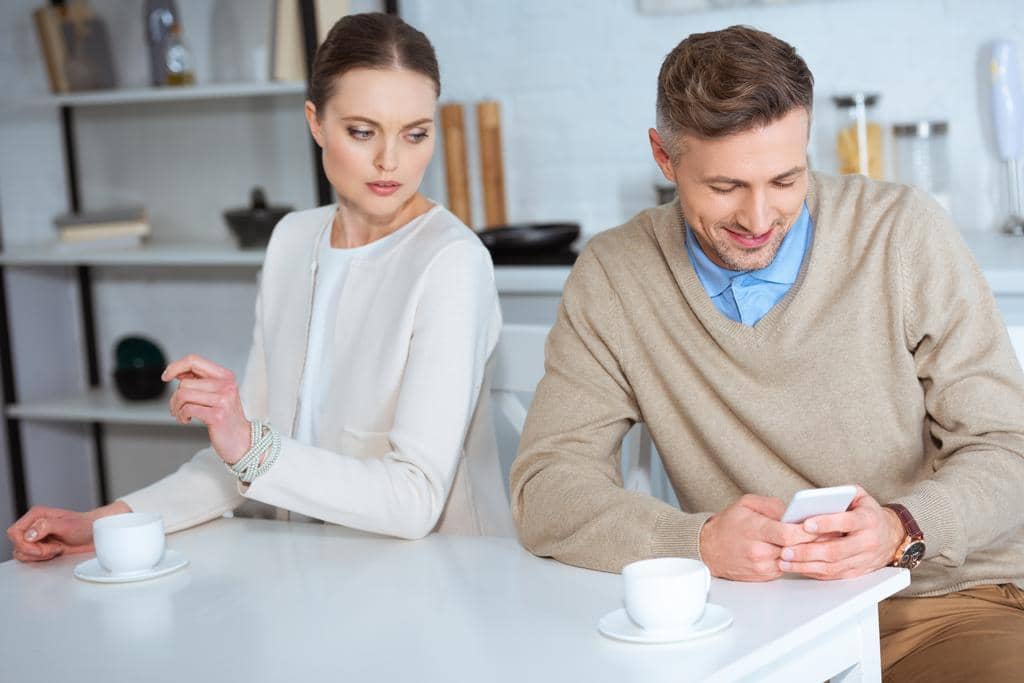 11 Types of Men Who Get Dumped: Brutal Reasons Women Leave 10 smiling man using smartphone ignoring woman breakfast kitchen
