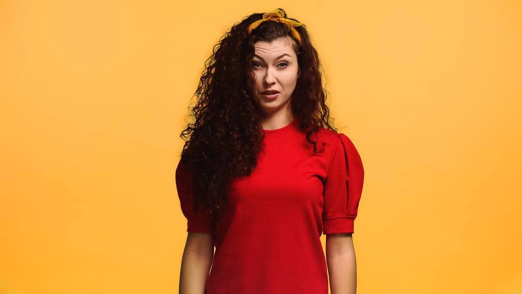 Why Men Mistake Kindness For Flirting 4 displeased woman feeling aversion while looking camera isolated orange