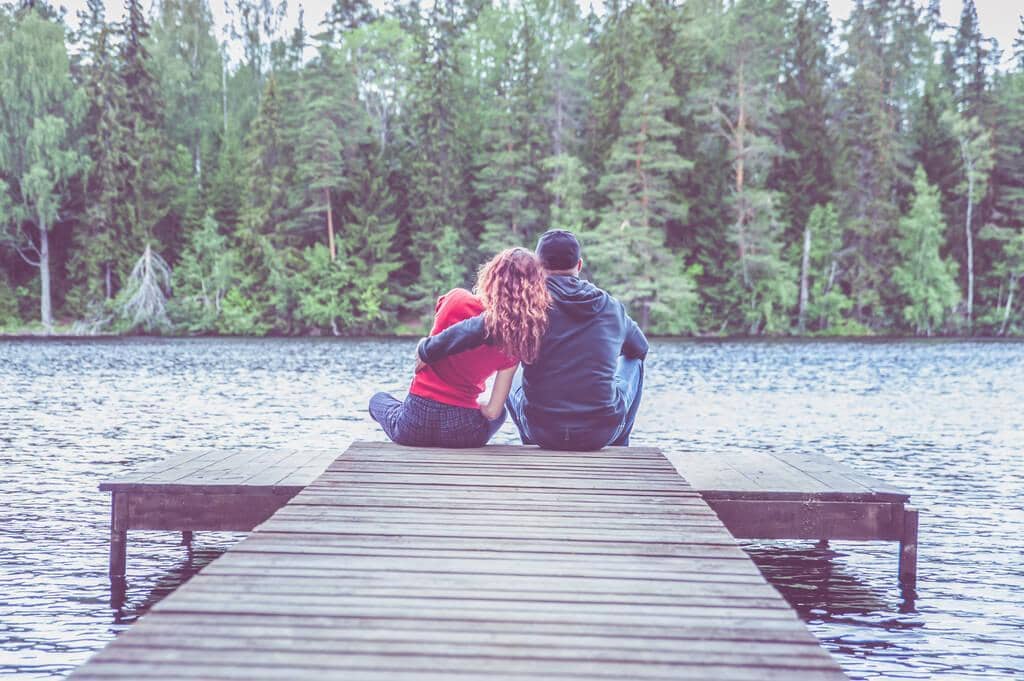 50 Painful Signs of an Emotionally Unavailable Husband 12 guy girl sit hugging pier beautiful lake concept love summer