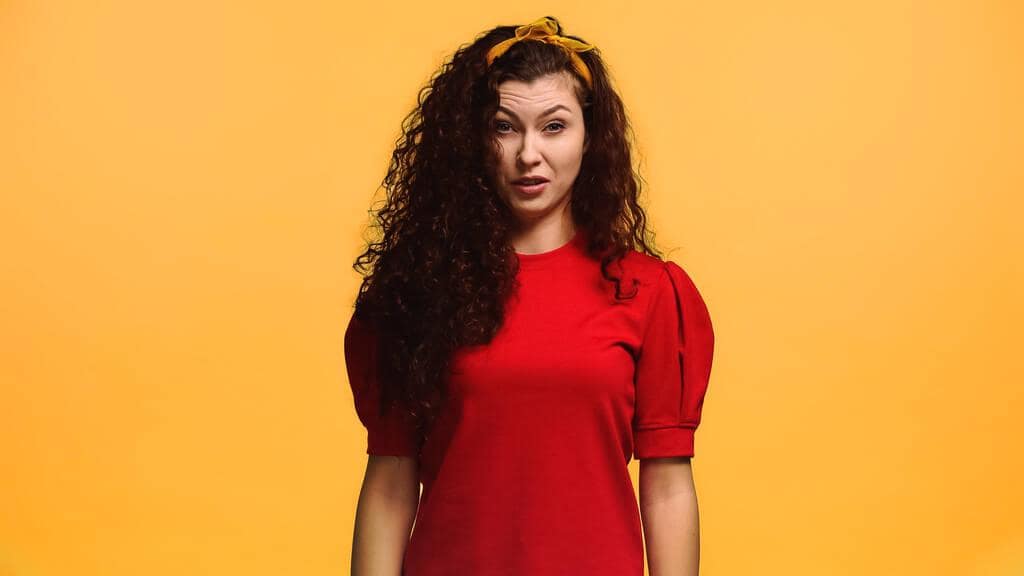 Why Men Mistake Kindness For Flirting 4 displeased woman feeling aversion while looking camera isolated orange