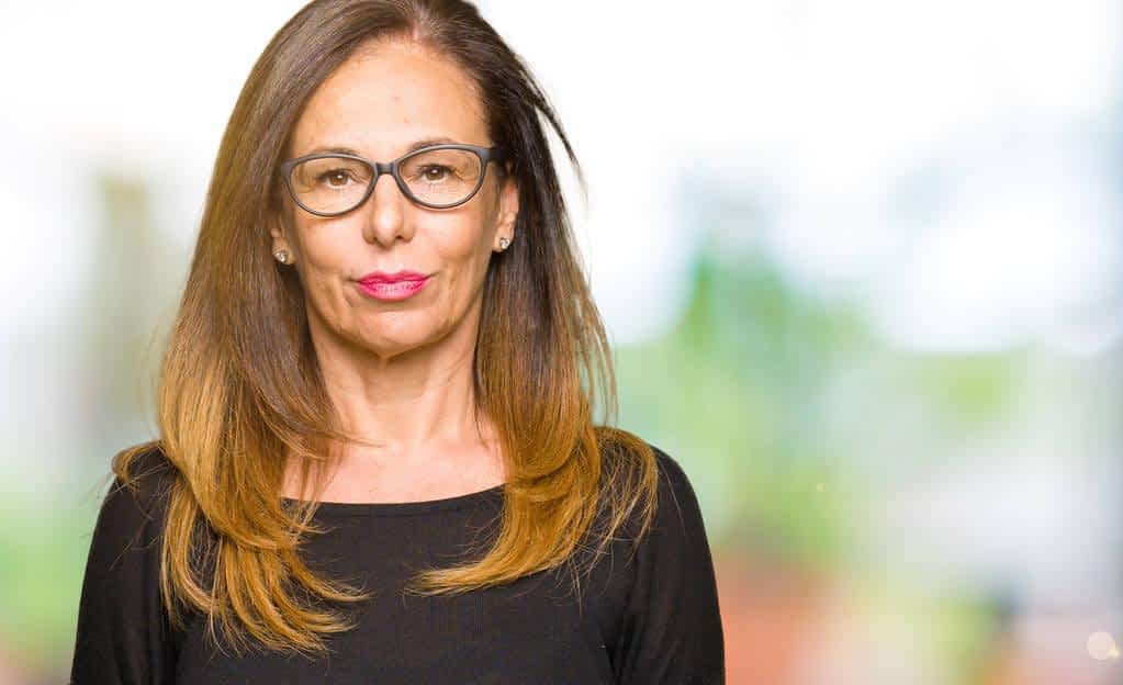 beautiful middle age woman wearing glasses serious expression face simple