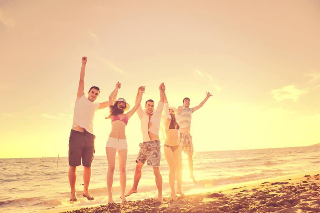 happy young friends group have fun celebrate while jumping running