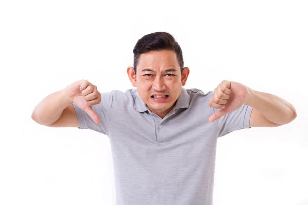 angry disappointed frustrated man giving thumb down gesture