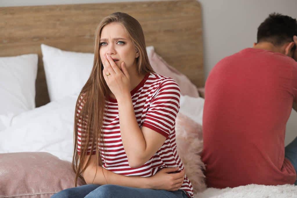 quarreled couple sitting on bed at home