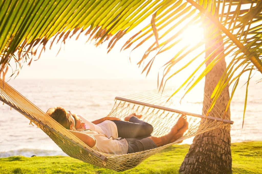 couple relaxing in tropical hammock