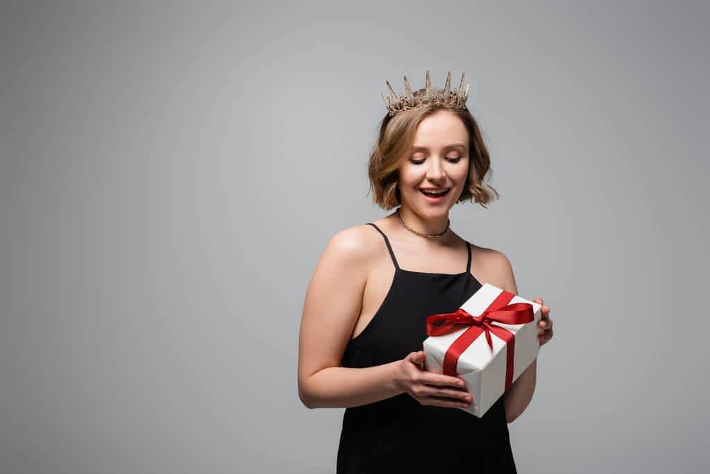 woman slip dress crown holding present isolated grey