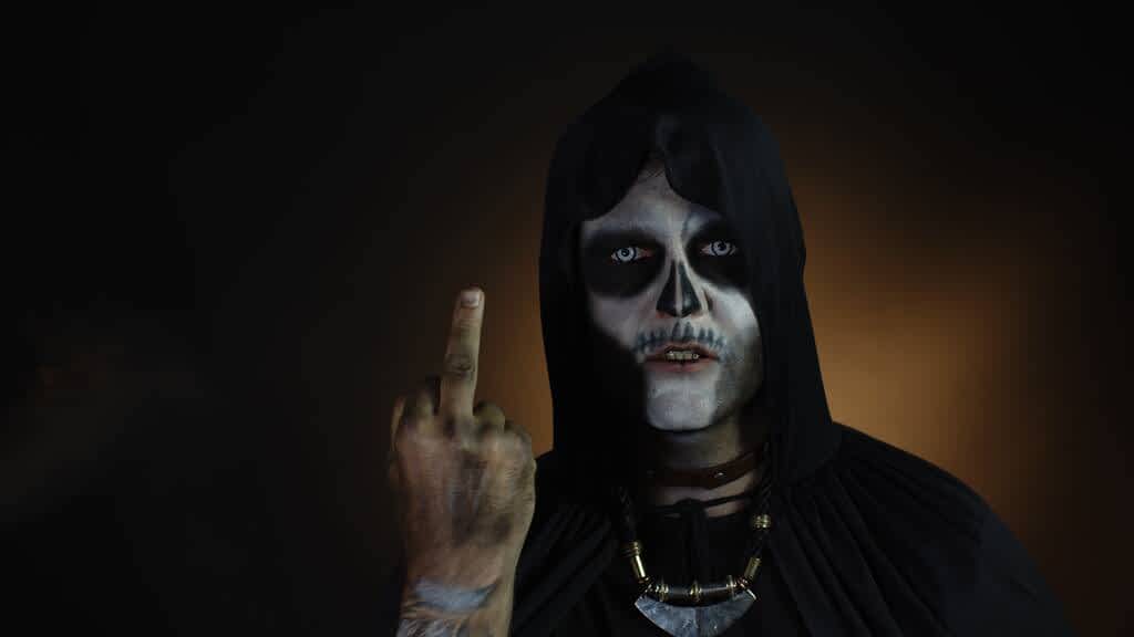 15 Disgusting, Sketchy Things Creepy Men Do 8 sinister man with skull makeup making faces and showing middle finger bad manner gesture halloween
