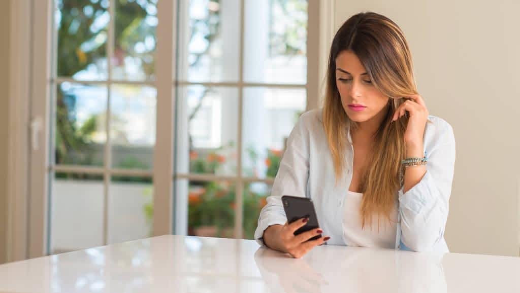 disgusted woman using smartphone