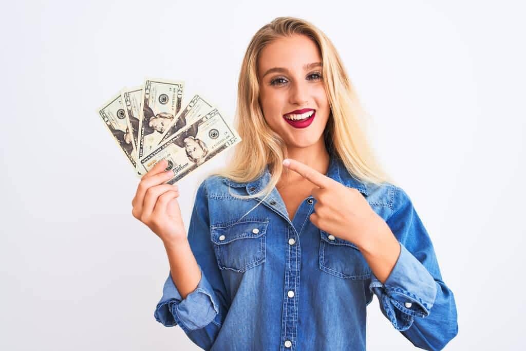 blond woman holding dollars standing isolated white background
