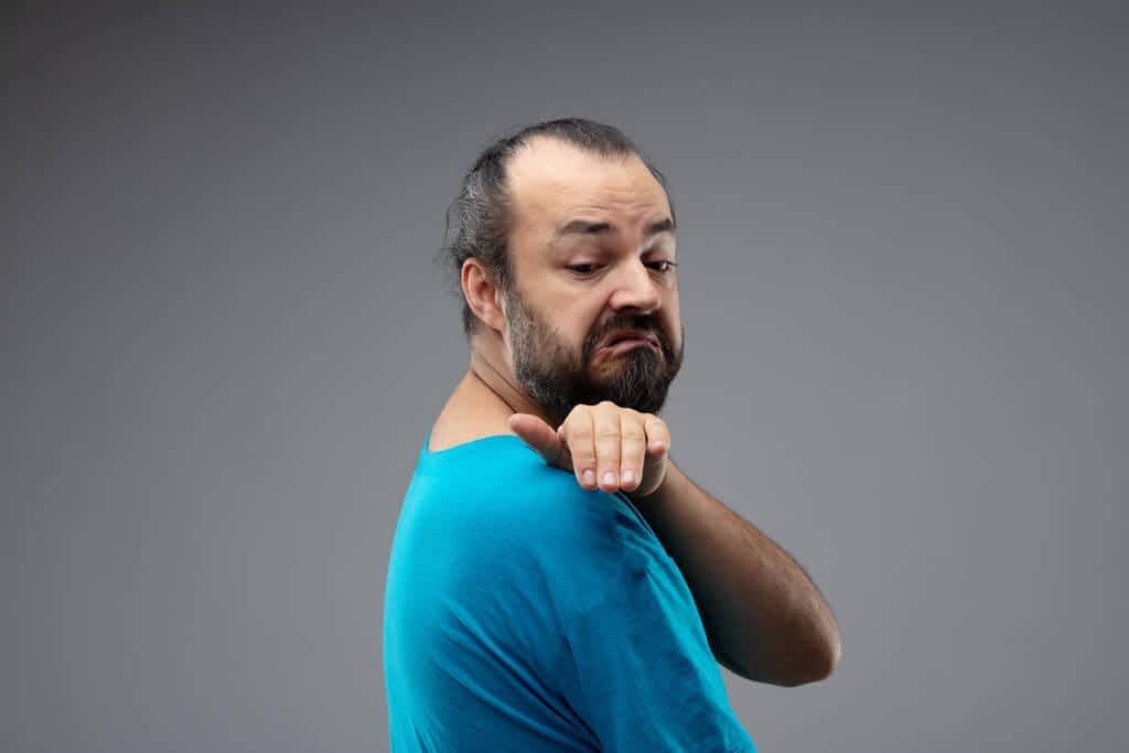 bearded man blue shirt doing brushing dirt his shoulder gesture