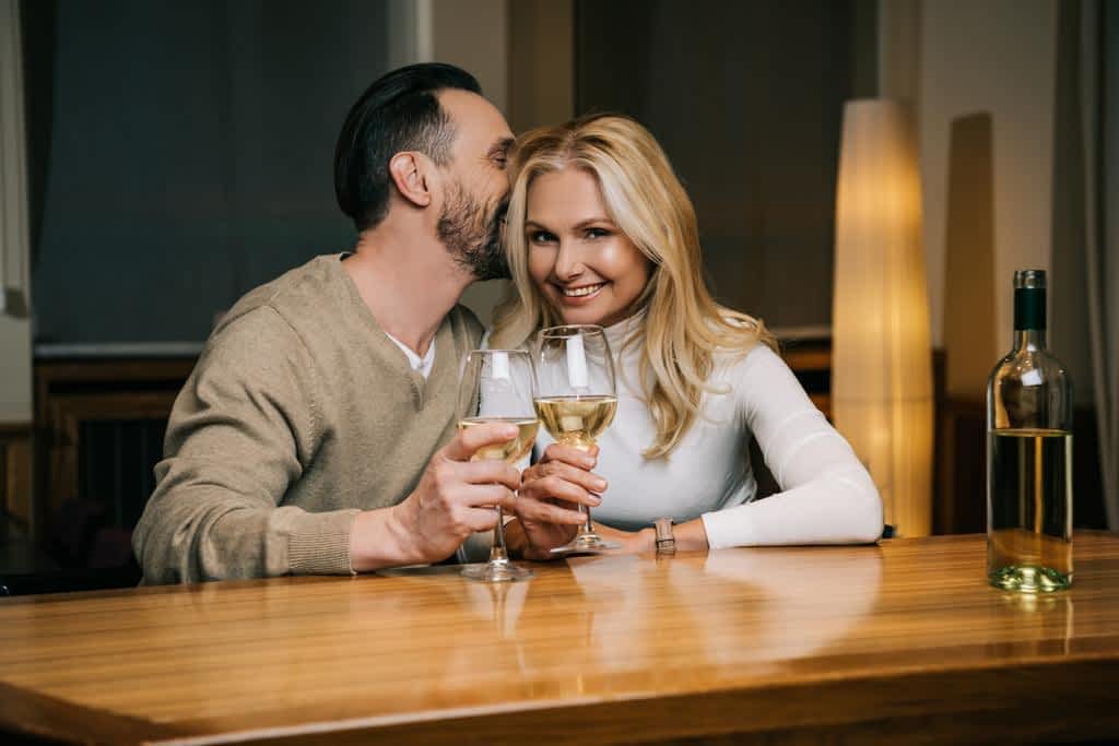 The 11 Unexpected Silver Linings of a Gray Divorce 5 handsome mature man whispering something smiling woman while drinking wine