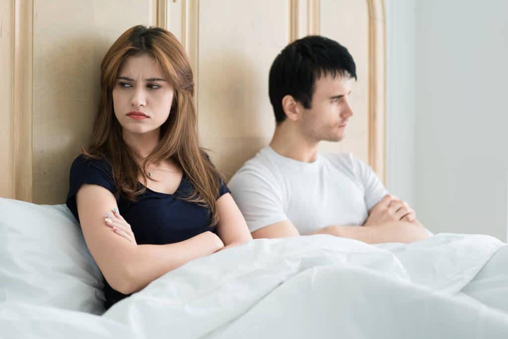 unhappy couple talking argument bed home people relationship difficulties family