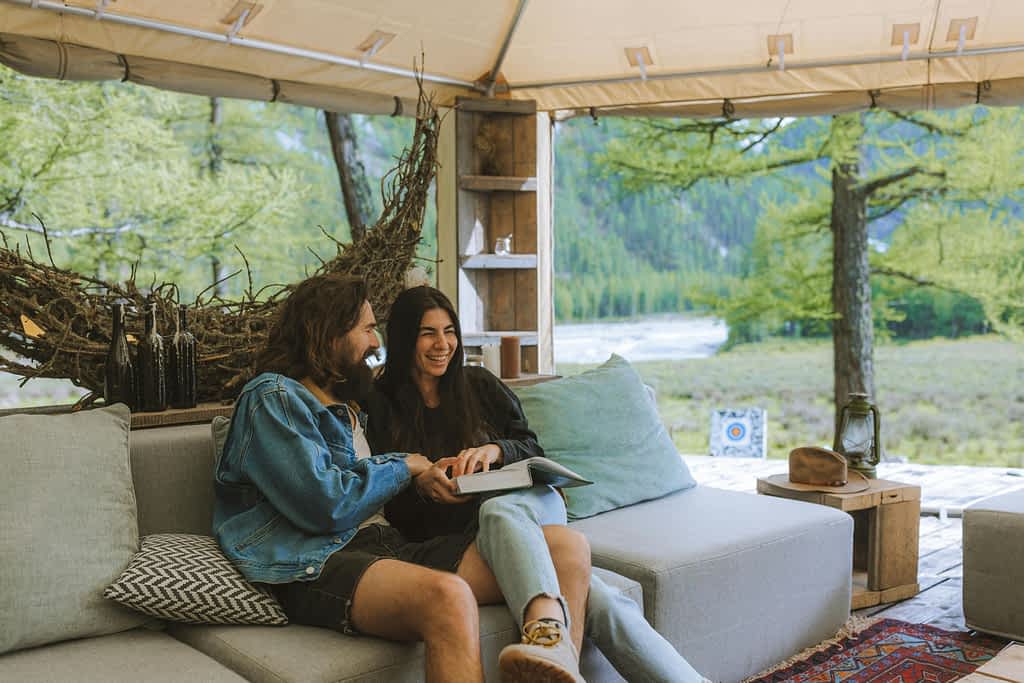 man and woman sitting under a covered patio and laughing