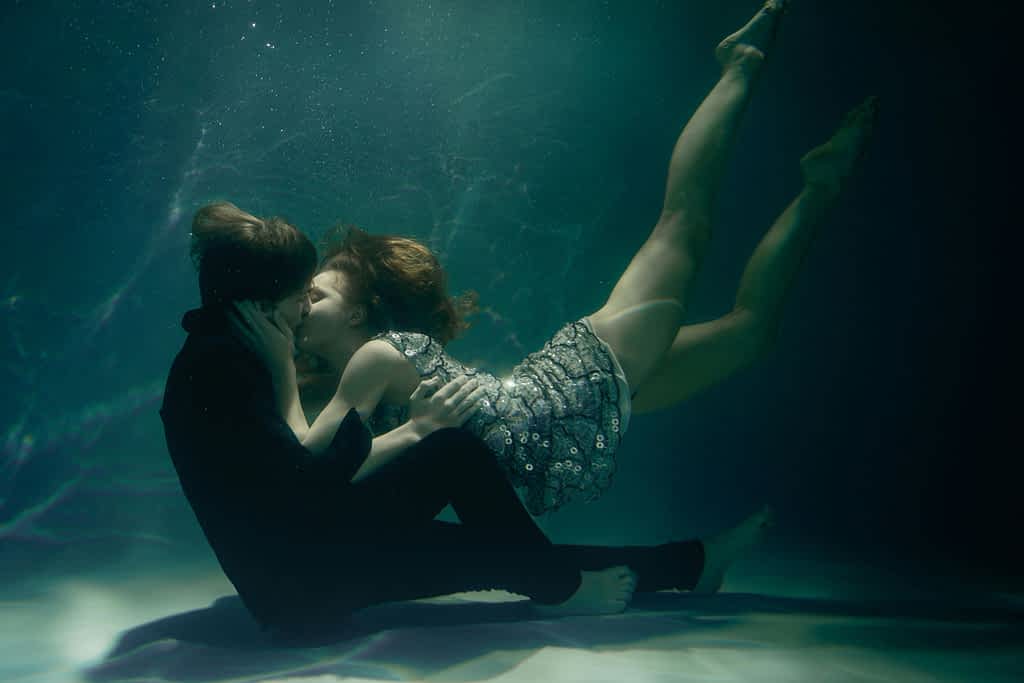 woman kissing man underwater