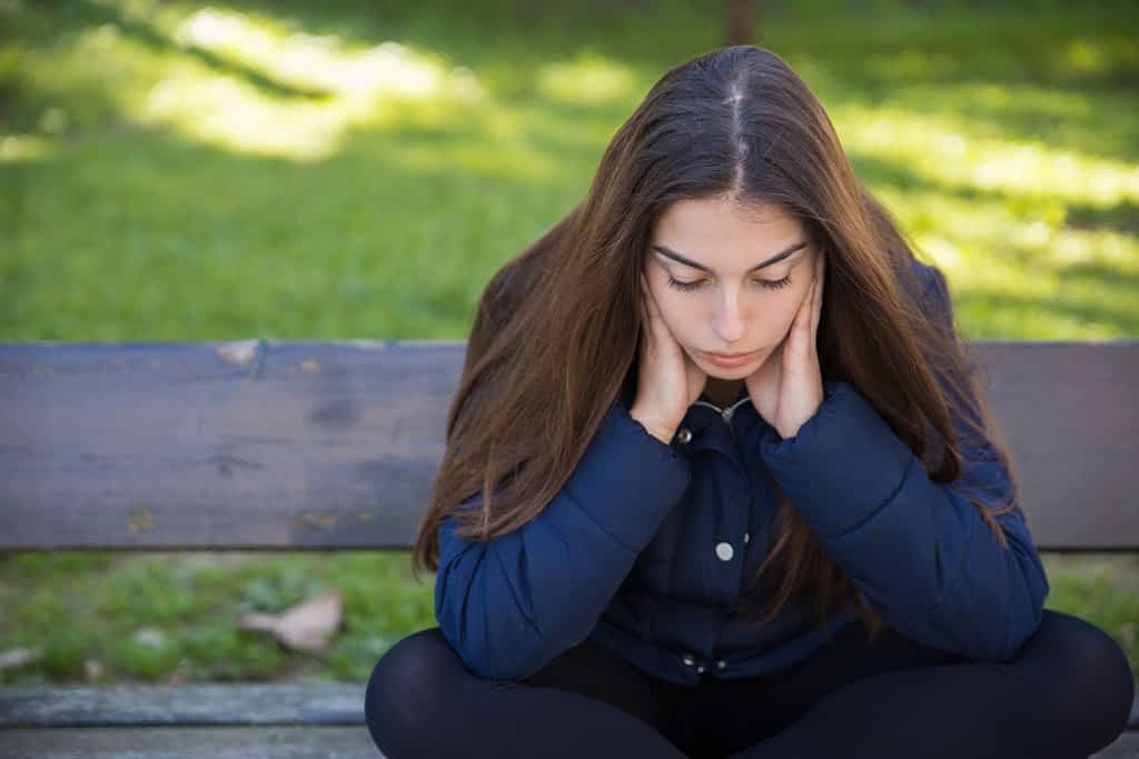 Stuck In A Difficult Marriage? Stop Waiting For Him to Change First 2 Pensive pretty woman sitting on bench in park thinking about wht to do because she is stuck in a difficult marriage she can't leave yet.