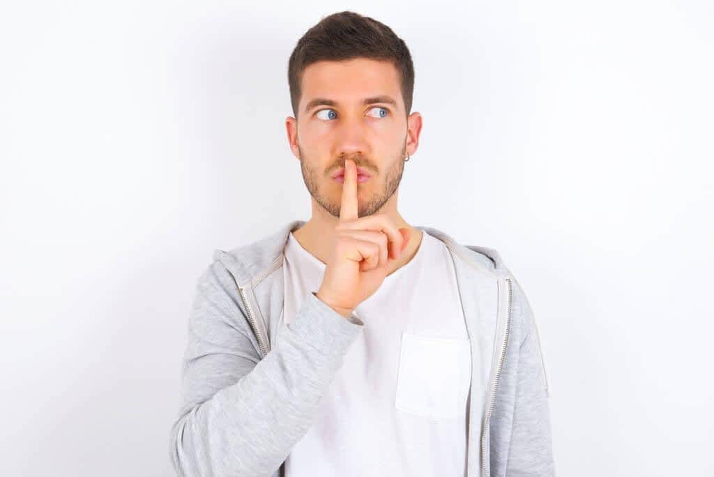caucasian man wearing casual clothes white background makes silence
