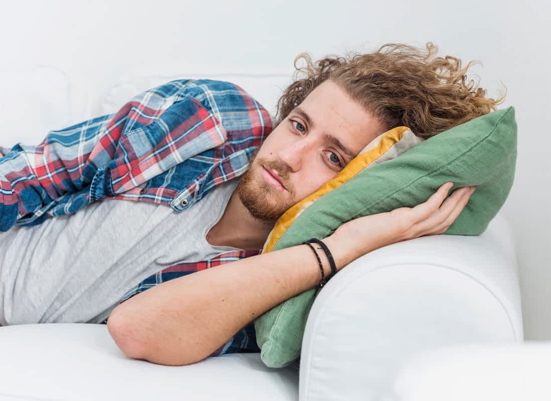 depressed man laying in bed