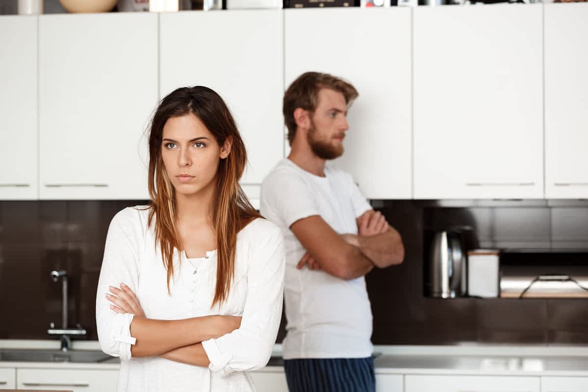 brunette woman in quarrel with her husband background at home.