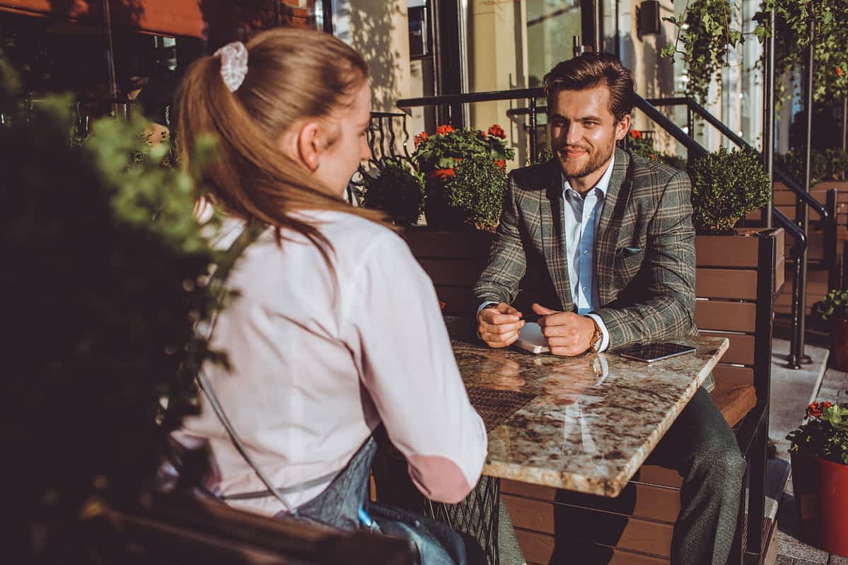 Man and woman sit outside on a date