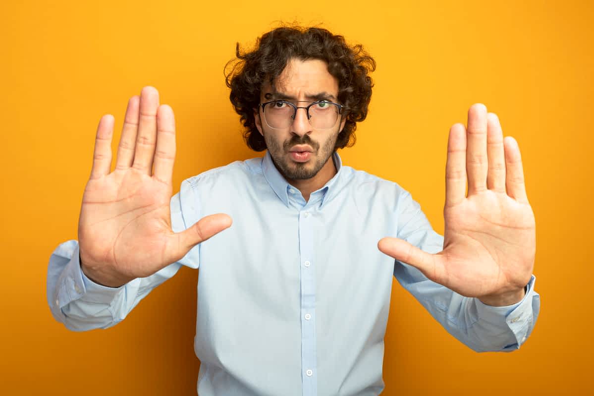 man holding his hands up in a "stop it" position