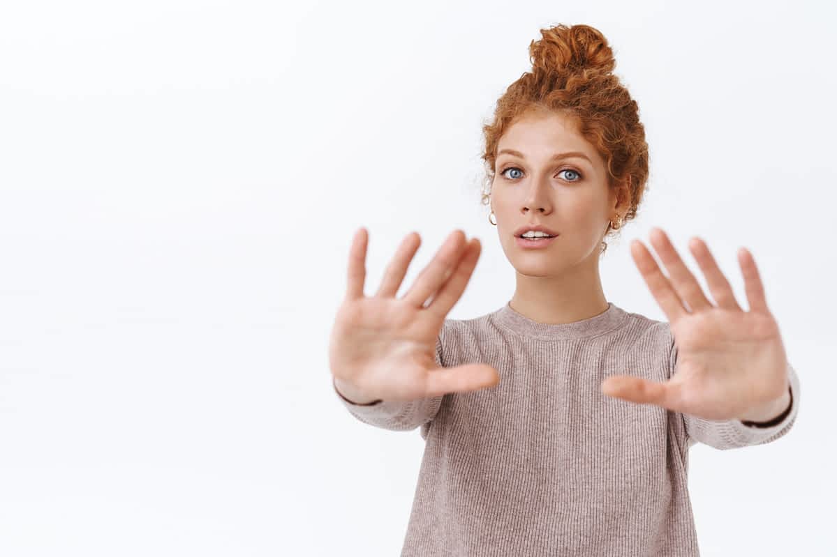 red head woman putting her hands up for a boundary