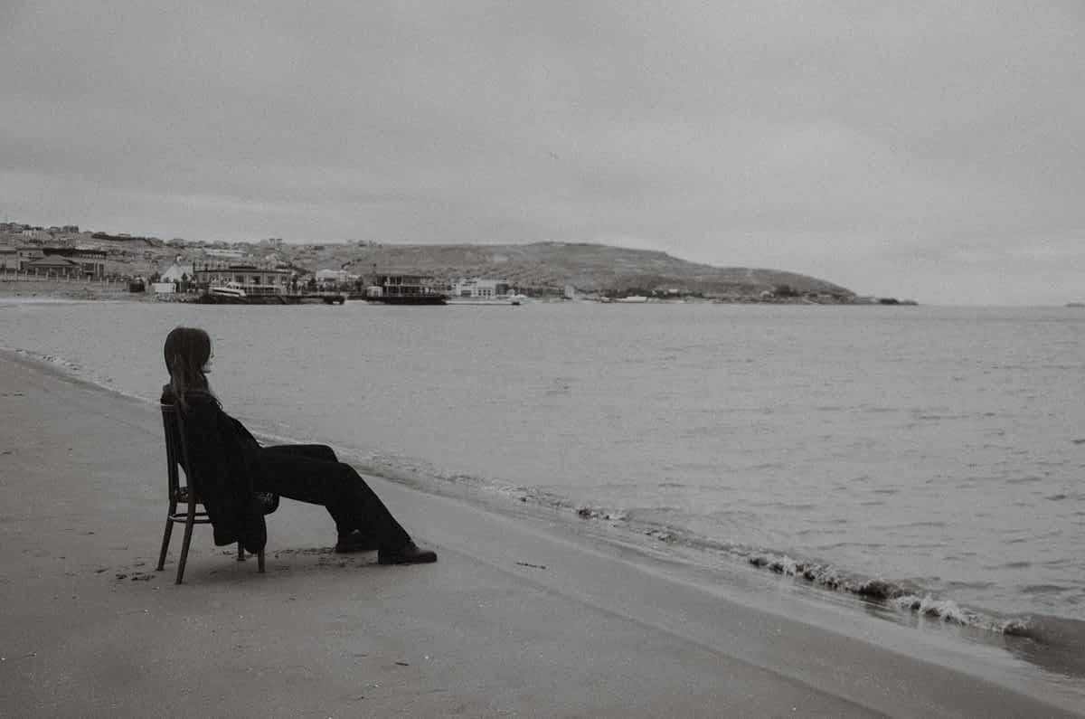 woman sitting on a chair alone a the beach
