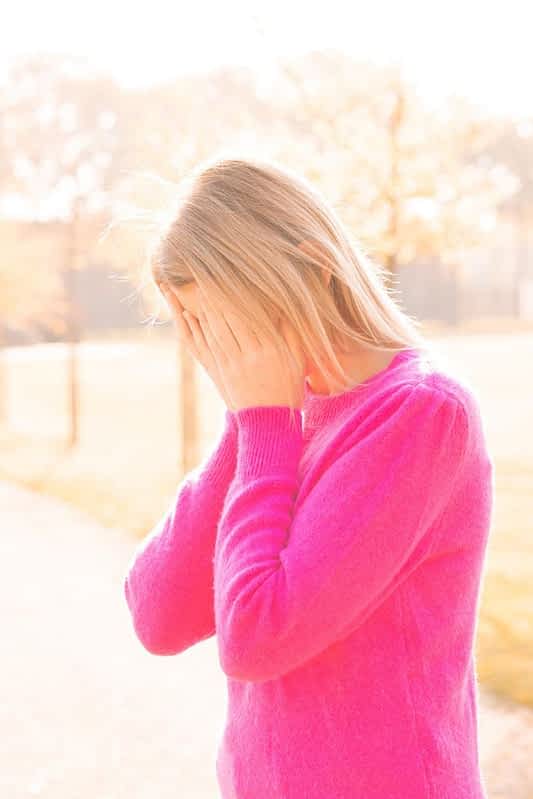 tired sad depressed young beautiful blonde woman burries her face