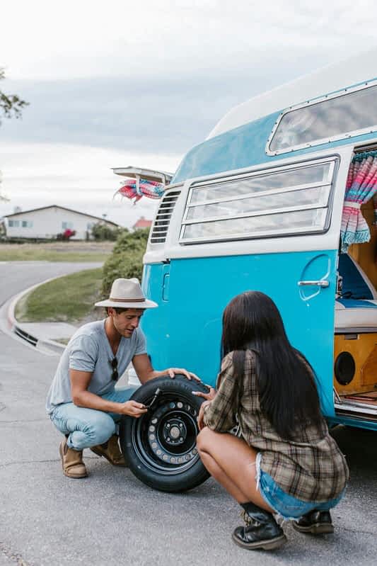 man helping woman change a tire
