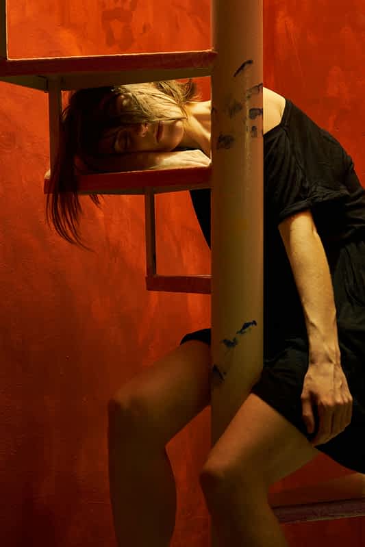 an exhausted tired woman falls asleep on a spiral staircase