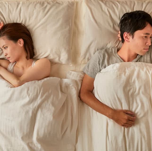 unhappy couple in bed