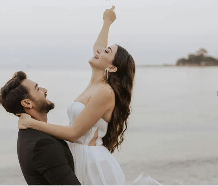 man holding woman at the beach